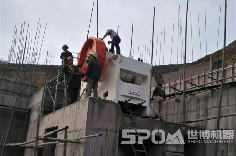 石場大型顎式破碎機安裝現(xiàn)場，需要四五人合力